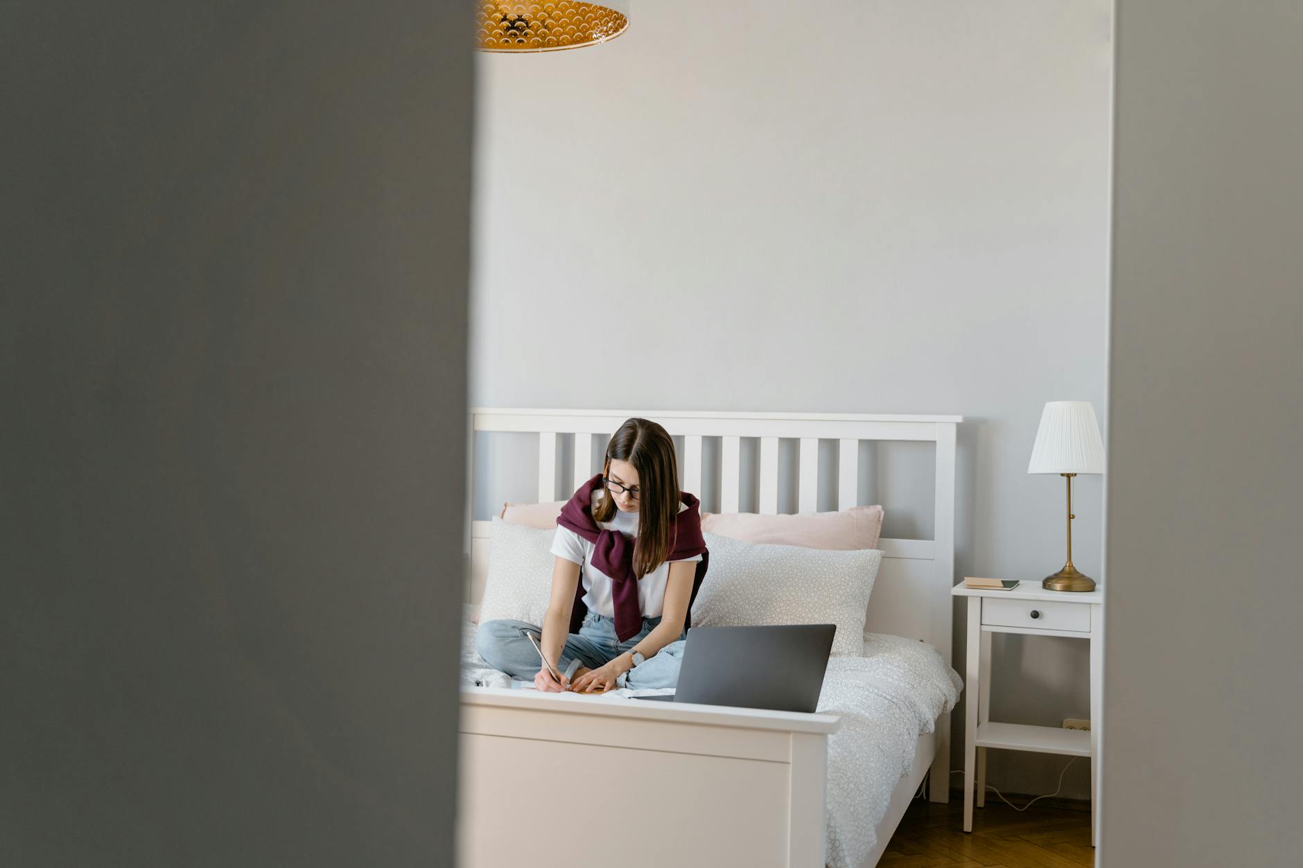 Nastolatka odrabiająca lekcje przy biurku w spokojnym pokoju młodzieżowym