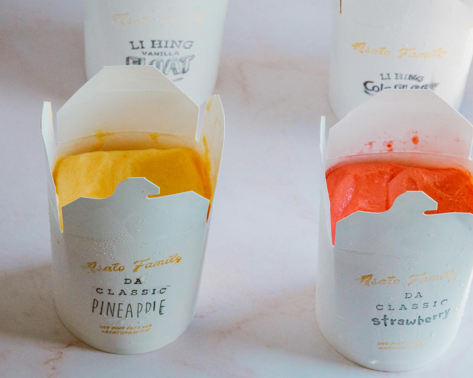 Lody o smakach ananasa i truskawki w kolorowych, firmowych opakowaniach