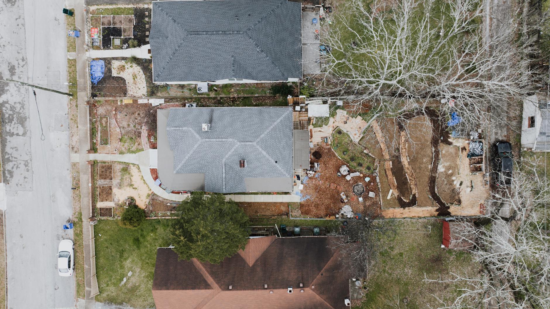 Widok z góry na osiedle domów z przydomowymi ogrodami