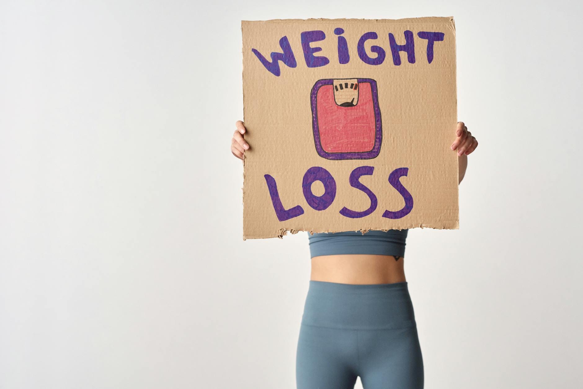 Osoba trzymająca kartkę z napisem weight loss jako motywacja do redukcji