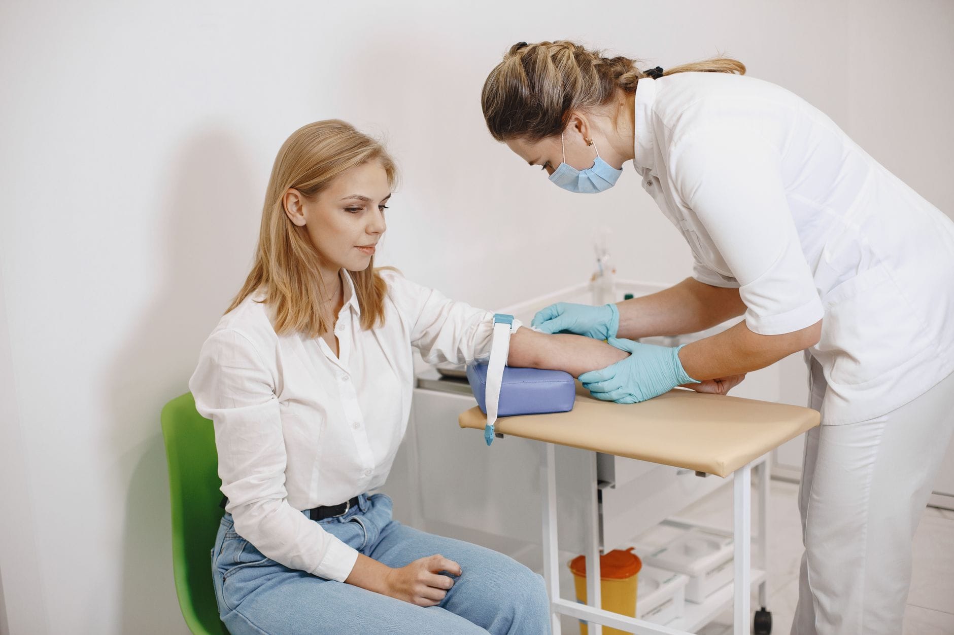 Homocysteina i B12: kiedy warto zbadać, jeśli masz mrowienie, zmęczenie i słabą regenerację Pielęgniarka pobiera krew kobiecie do badania poziomu homocysteiny i B12