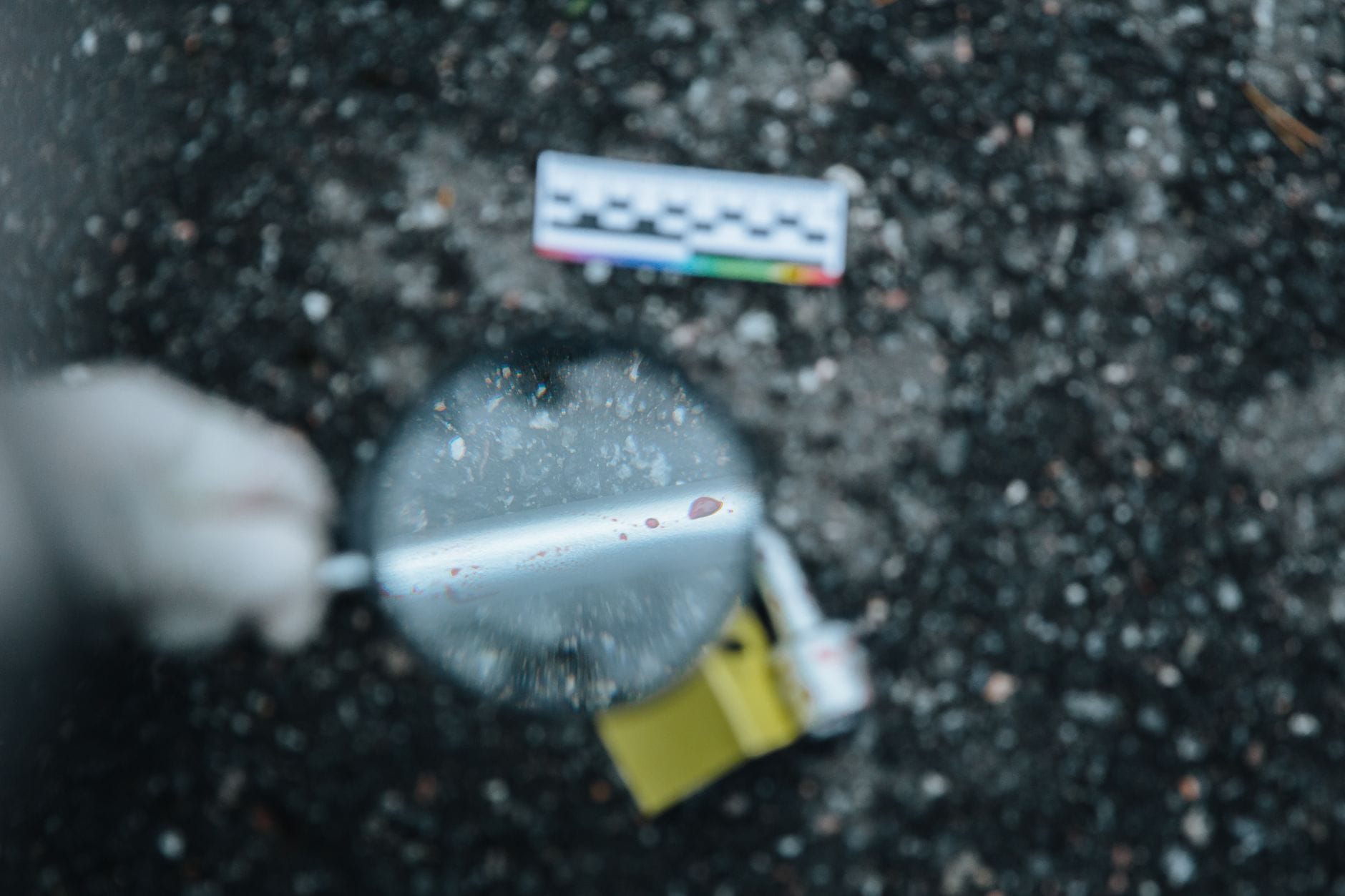 Lupa analizująca ślad dowodowy na miejscu zbrodni