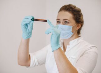 Badania hormonalne u kobiet trenujących: w których dniach cyklu badać estradiol, progesteron i prolaktynę? Pracownica medyczna bada próbkę krwi w probówce